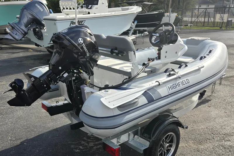 Slide: The Image of 2025 Highfield Classic 310 inflatable boat with Tohatsu outboard motor on a trailer. - 3