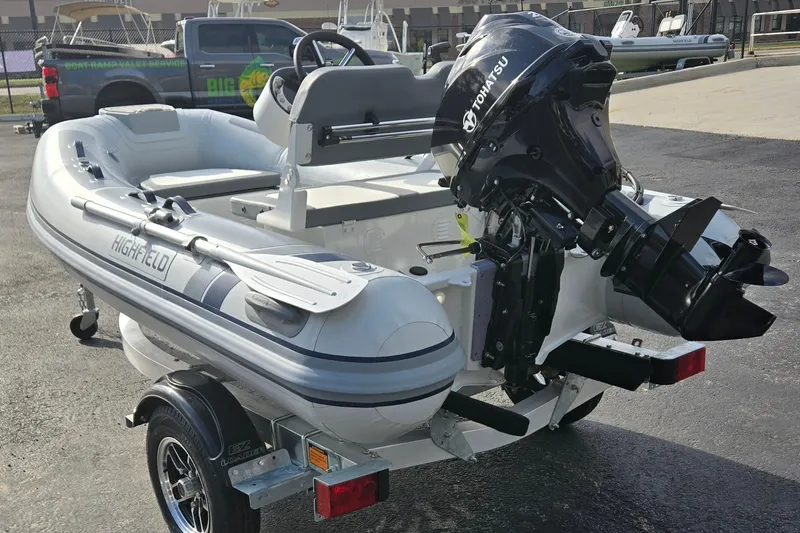 Slide: The Image of 2025 Highfield Classic 310 inflatable boat with Tohatsu outboard motor on a trailer. - 5