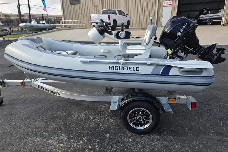 Slide: The Image of 2025 Highfield Classic 310 inflatable boat on trailer with Tohatsu outboard motor. - 6