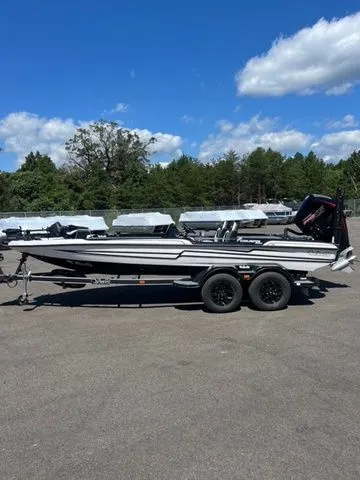 Slide: The Image of 2026 Bass Cat Cougar FTD SP boat on trailer, parked outdoors under a clear blue sky. - 1