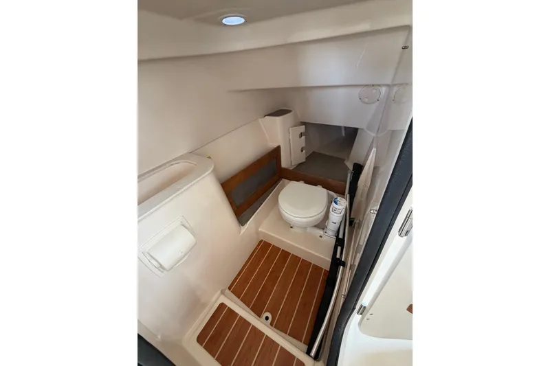 Slide: The Image of 2026 Grady-White Freedom 285 boat interior with compact bathroom and wooden flooring. - 10