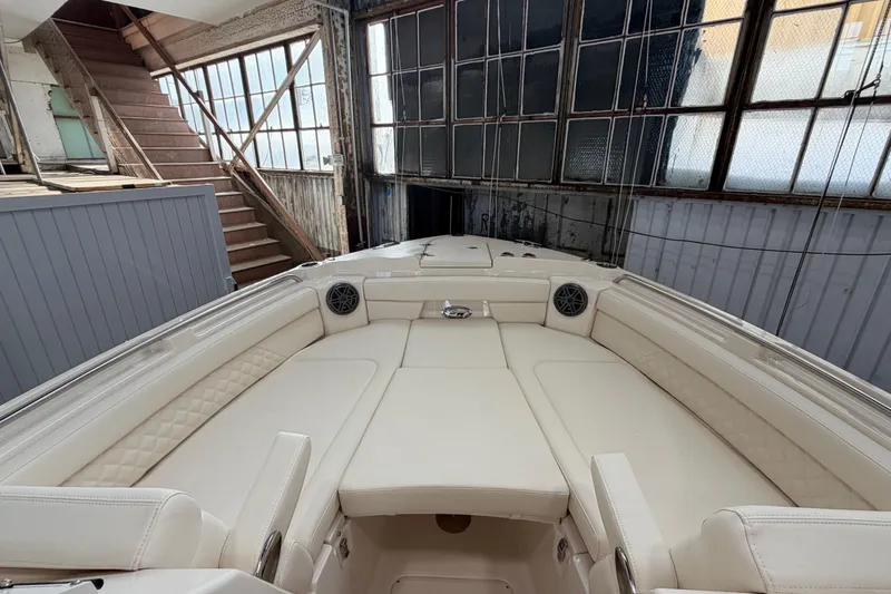 Slide: The Image of 2026 Grady-White Freedom 285 boat interior with luxurious seating in a warehouse setting. - 12