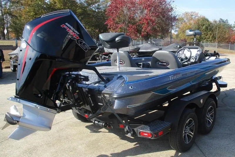 Slide: The Image of 2026 Triton 18 TrX bass boat with powerful outboard motor, parked on a trailer. - 2