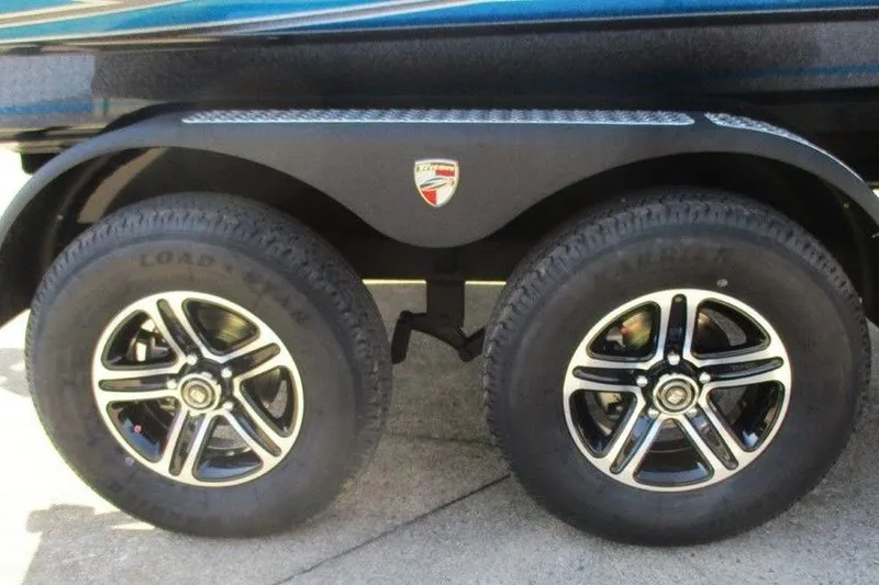 Slide: The Image of 2026 Triton 18 TrX trailer wheels with black alloy rims and branded fender. - 4