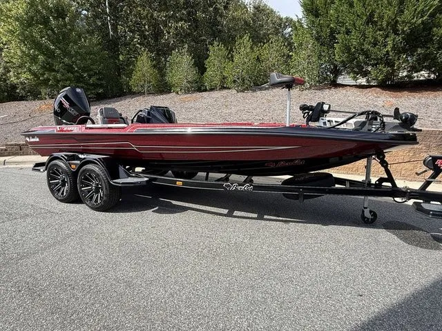 Slide: The Image of 2026 Bass Cat Lynx STS boat on trailer, parked outdoors, featuring sleek design and modern equipment. - 3