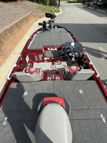 Slide: The Image of 2026 Bass Cat Lynx STS boat interior with red and gray seating, steering console, and fishing equipment. - 5