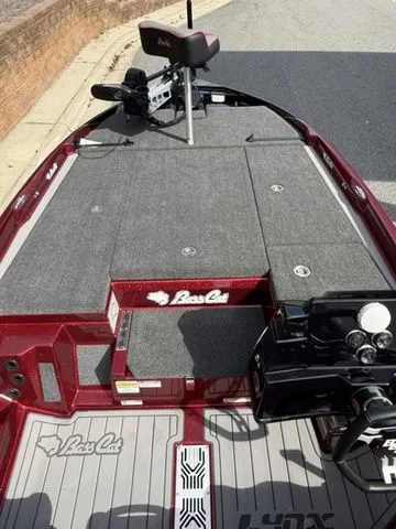 Slide: The Image of 2026 Bass Cat Lynx STS boat deck with gray carpeting and red accents. - 8