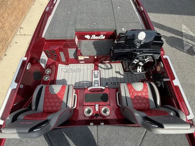 Slide: The Image of 2026 Bass Cat Lynx STS boat interior with red and gray seating, dashboard, and storage compartments. - 7