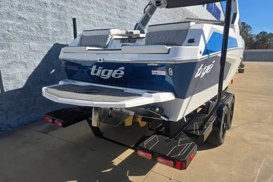 Slide: The Image of 2026 Tigé 22RZX boat on trailer, blue and white design, rear view. - 10
