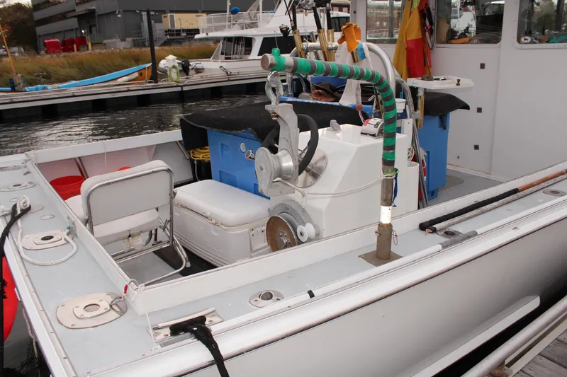 Slide: The Image of 2002 Libby 38 Downeast boat docked, featuring fishing equipment and seating area. - 13