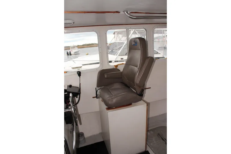 Slide: The Image of Captain's chair in 2002 Libby 38 Downeast boat interior, with windows and controls. - 18