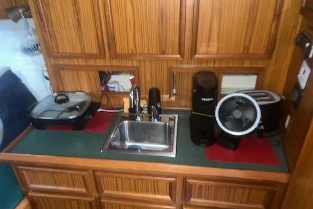 Slide: The Image of Compact kitchen area in a 2002 Libby 38 Downeast boat with sink and appliances. - 21