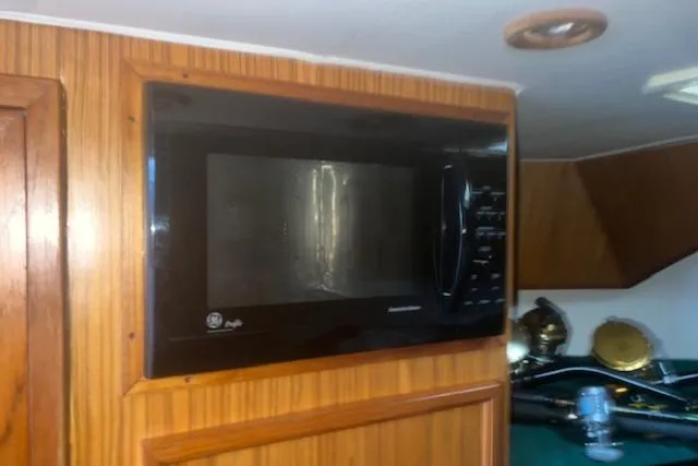 Slide: The Image of Built-in microwave in a 2002 Libby 38 Downeast boat interior with wood paneling. - 25