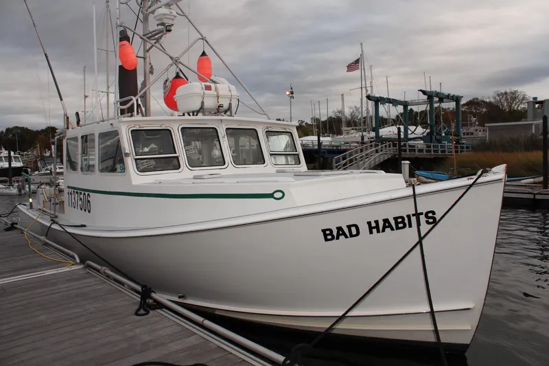 Slide: The Image of 2002 Libby 38 Downeast boat "Bad Habits" docked at marina with overcast sky. - 4