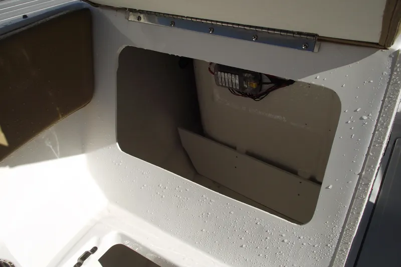 Slide: The Image of 2026 Bayliner V20 boat compartment with open hatch and visible wiring. - 12
