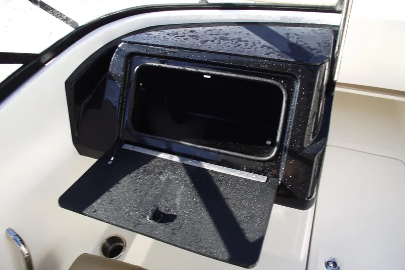 Slide: The Image of Open storage compartment on 2026 Bayliner V20 boat, featuring sleek black interior. - 17