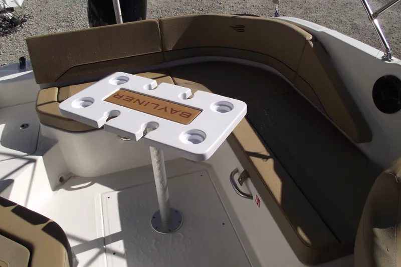 Slide: The Image of 2026 Bayliner V20 boat interior with seating and table, featuring cup holders. - 23