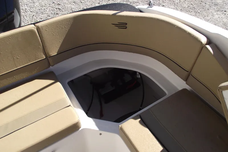 Slide: The Image of 2026 Bayliner V20 boat interior with tan cushioned seating and storage compartment. - 27