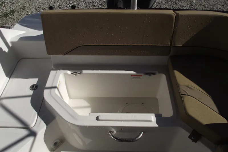 Slide: The Image of 2026 Bayliner V20 boat seating area with storage compartment, featuring beige cushions. - 29