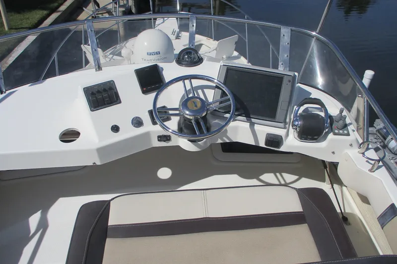 Slide: The Image of 2015 Cutwater 30 Command Bridge LE helm with steering wheel and navigation controls. - 14
