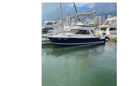 Slide: The Image of 2015 Cutwater 30 Command Bridge LE yacht docked in marina with cityscape background. - 2