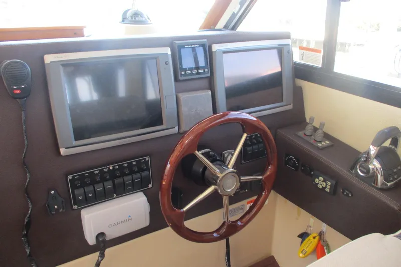Slide: The Image of 2015 Cutwater 30 Command Bridge LE helm with dual screens and wooden steering wheel. - 23