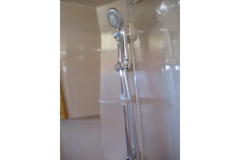 Slide: The Image of Shower area in 2015 Cutwater 30 Command Bridge LE boat, featuring chrome fixtures. - 40