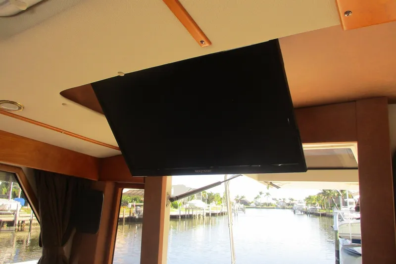 Slide: The Image of Interior of 2015 Cutwater 30 Command Bridge LE with ceiling-mounted TV and marina view. - 43