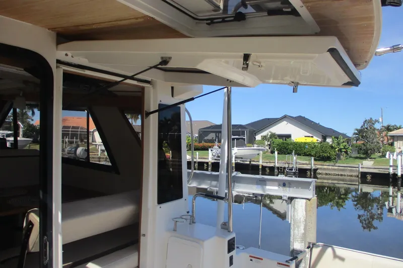 Slide: The Image of 2015 Cutwater 30 Command Bridge LE boat interior with open hatch, dockside view. - 7