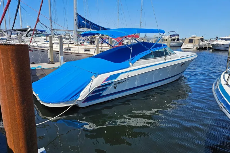 Slide: The Image of 1997 Formula 330 Sun Sport boat interior with white seating and table. - 2