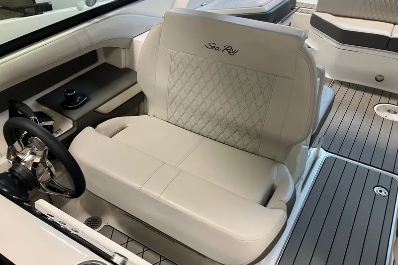 Slide: The Image of 2026 Sea Ray SLX 310 Outboard helm seat with luxurious beige upholstery and diamond stitching. - 12