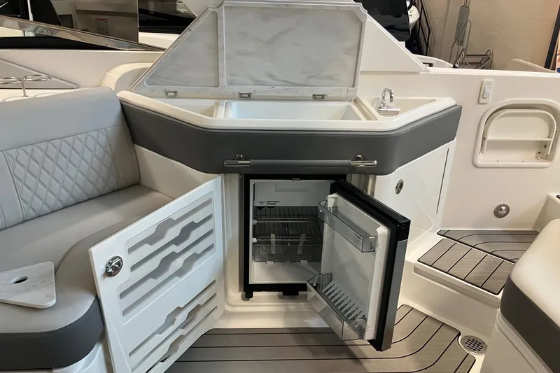 Slide: The Image of Luxury interior of 2026 Sea Ray SLX 310 Outboard with open fridge and sink. - 7