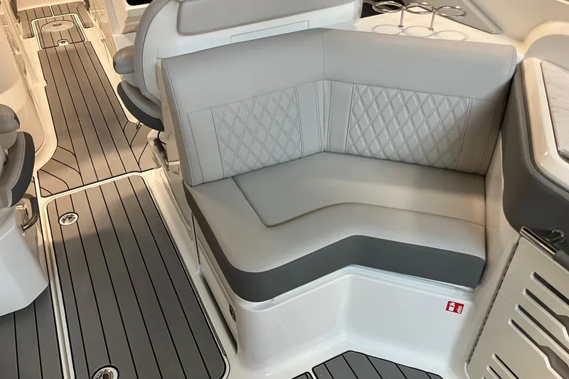 Slide: The Image of 2026 Sea Ray SLX 310 Outboard interior with gray seating and sleek flooring. - 8
