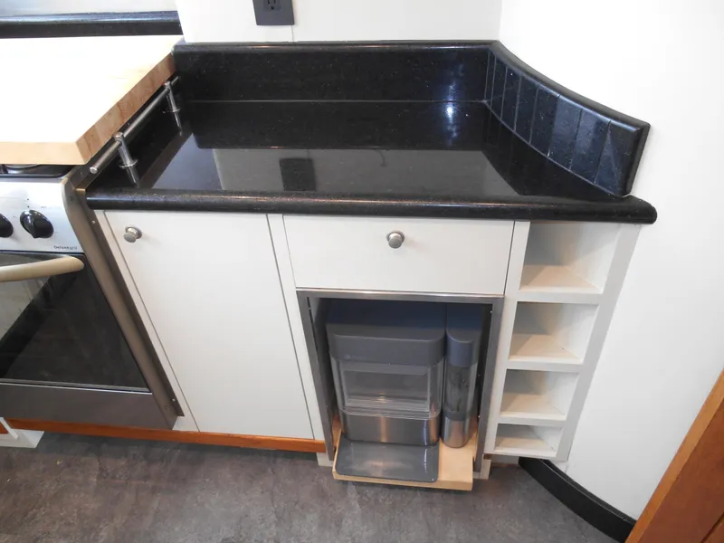 Slide: The Image of Compact kitchen counter with black granite top and storage on a 2005 Inace Trawler. - 17