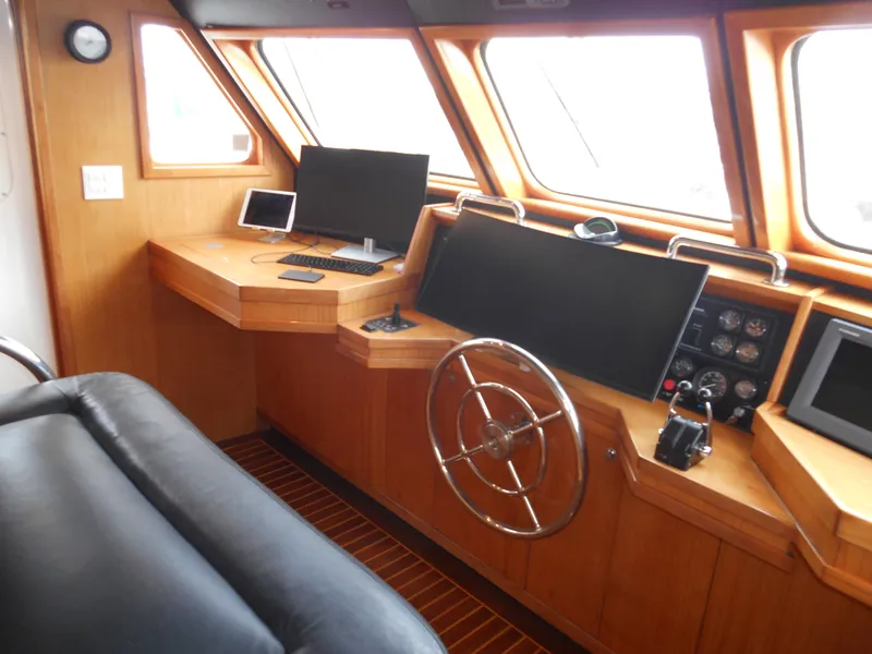 Slide: The Image of 2005 Inace Trawler helm with wooden interior, steering wheel, and navigation equipment. - 21