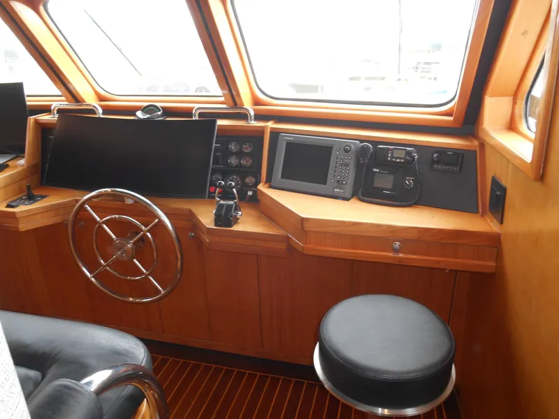 Slide: The Image of 2005 Inace Trawler helm with steering wheel, navigation equipment, and wooden interior. - 22