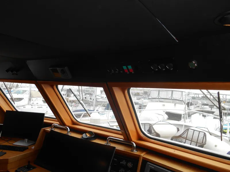 Slide: The Image of 2005 Inace Trawler helm with navigation equipment and marina view. - 29