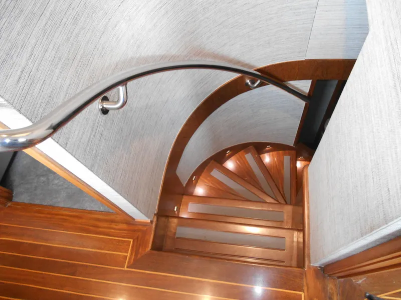 Slide: The Image of Wooden spiral staircase inside 2005 Inace Trawler yacht, featuring sleek handrail and modern design. - 30
