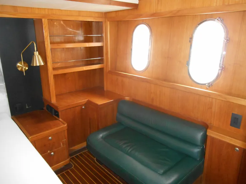 Slide: The Image of 2005 Inace Trawler interior with wooden cabinetry, green sofa, and porthole windows. - 41