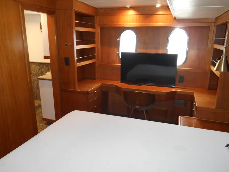 Slide: The Image of 2005 Inace Trawler interior with wooden desk, TV, and porthole windows. - 46
