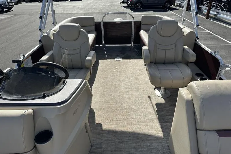 Slide: The Image of 2020 Sweetwater SW 2286 SB pontoon boat interior with beige seating and steering console. - 11