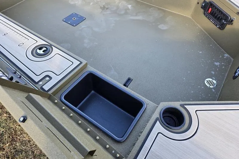 Slide: The Image of Interior view of 2025 Avid 16 Commander boat, featuring storage compartments and cup holders. - 12