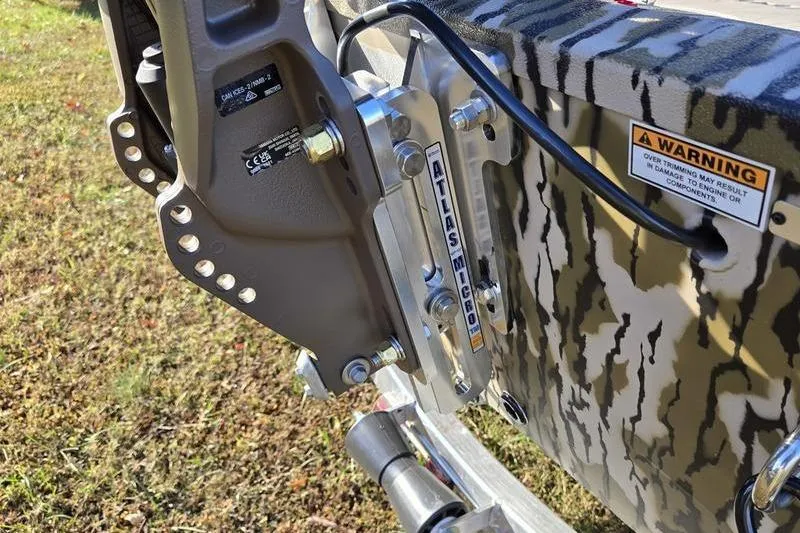 Slide: The Image of Close-up of 2025 Avid 16 Commander boat motor mount with camouflage pattern and warning label. - 2