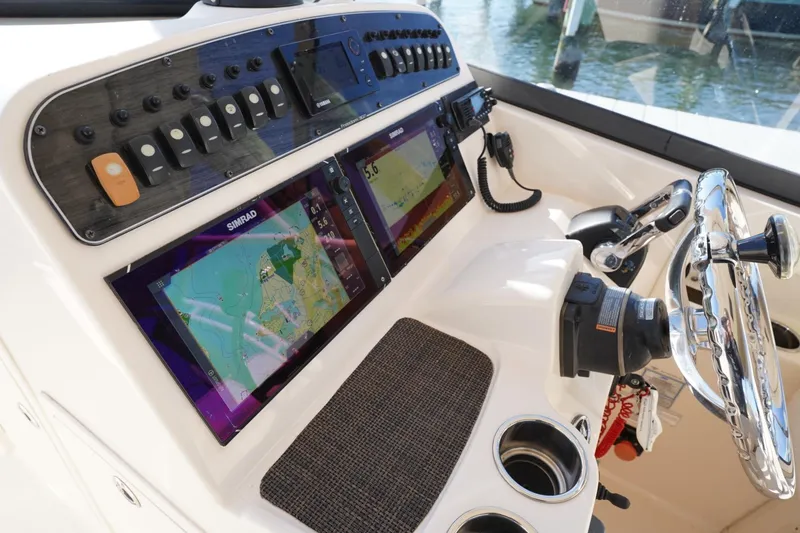 Slide: The Image of 2015 Grady-White Freedom 307 boat dashboard with navigation screens and controls. - 18