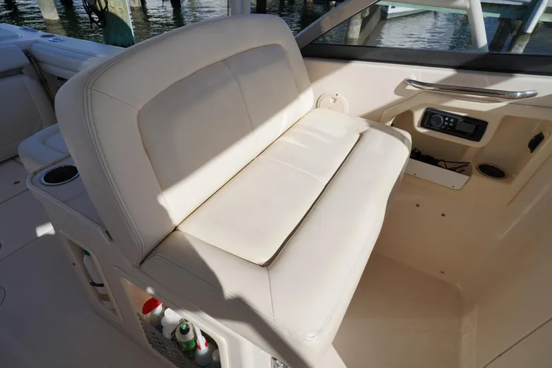 Slide: The Image of 2015 Grady-White Freedom 307 boat interior with beige seating and storage compartments. - 22