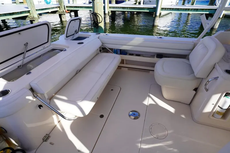 Slide: The Image of 2015 Grady-White Freedom 307 boat interior with white seating and storage compartments. - 23