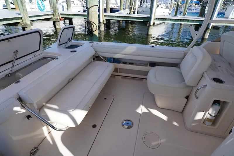Slide: The Image of 2015 Grady-White Freedom 307 boat interior with seating and storage, docked at marina. - 24