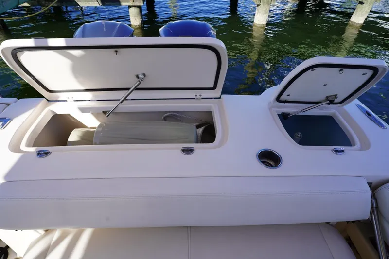 Slide: The Image of 2015 Grady-White Freedom 307 boat storage compartments open by the water. - 28