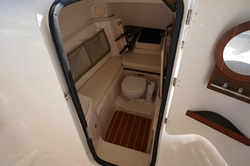 Slide: The Image of 2015 Grady-White Freedom 307 boat interior with compact bathroom and wooden accents. - 34