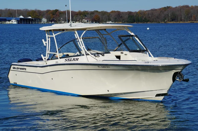 Slide: The Image of 2015 Grady-White Freedom 307 boat with dual Yamaha engines on a serene lake. - 6